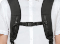 Correas de mochila negras sobre una persona con camisa blanca