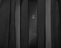 Primer plano de una mochila negra con el logotipo de la marca en la tela.