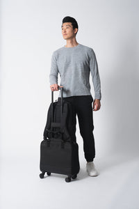 Hombre con una maleta negra sobre fondo blanco
