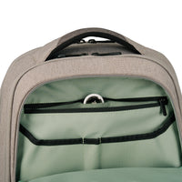 Close-up of the interior of a backpack, showing a sage green lining with black zipper compartments and a top handle.