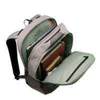 An open gray and sage green backpack shown from the side, filled with a laptop and notebooks, on a solid white background.